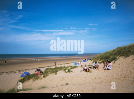 Sanddünen mit grasbewachsenen Büschel über dem breiten goldenen Sandstrand von Holkham Bay Norfolk Stockfoto