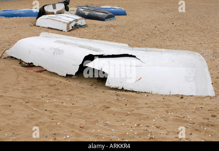 Ein gebrochen weißen GFK-Ruderboot liegt an einem Sandstrand Stockfoto