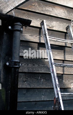 Neue schwarze Gusseisen Dachrinnen und Fallrohr installiert auf einer schwarzen weatherboarded Scheune Stockfoto