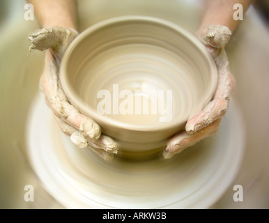 Person, die Keramiktopf auf der Töpferscheibe Stockfoto
