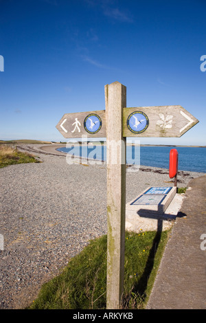 Insel von ANGLESEY COASTAL PATH Schild mit Logo zeigt West entlang Kiesstrand bei Cemlyn Bay Isle of Anglesey North Wales UK Stockfoto