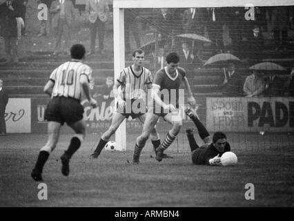 Fußball, Regionalliga West, 1966/1967, Westfalia Herne vs. Alemannia Aachen 0:0, Stadion bin Schloss Struenkede in Herne, Regen, Regenwetter, Szene des Spiels, v.l.n.r. Akteur Aachen (10), Erwin Hermandung (Aachen), ein Herne-Spieler, Keeper Gerhard Stockfoto