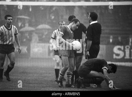 Fußball, Regionalliga West, 1966/1967, Westfalia Herne vs. Alemannia Aachen 0:0, Stadion bin Schloss Struenkede Herne, Regen, Regenwetter, Szene des Spiels, v.l.n.r. Rolf Pawellek (Aachen), Werner Nievelstein (Aachen) abgedeckt, Keeper Gerhard Prok Stockfoto