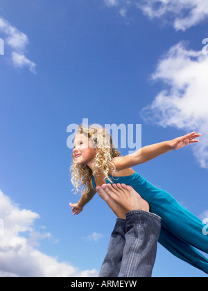 Junges Mädchen wirbelnde Füße in der Luft Stockfoto