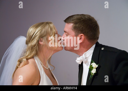 Braut und Bräutigam küssen bei Trauung Stockfoto
