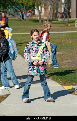 Grundschule Crossing Guard bietet Sicherheit für Kinder überqueren von verkehrsreichen Straßen Straßen Autobahnen beim Heimweg von der Schule Stockfoto