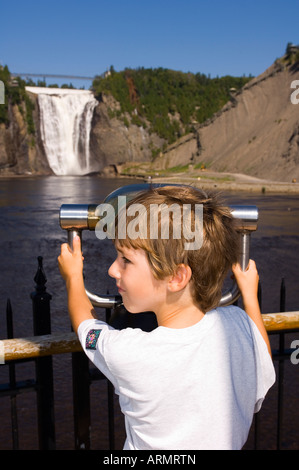 Junge blickt durch Viewscope an den Montmorency Falls, befindet sich 10 km östlich von Quebec Stadt, Quebec, Kanada. Stockfoto