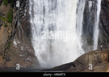 Frau mit ausgestreckten Armen an den Montmorency Falls, befindet sich 10 km östlich von Quebec Stadt, Quebec, Kanada. Stockfoto