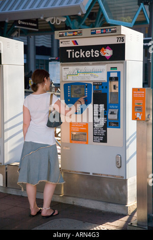 Junge Frau kauft die Karten für die Hudson-Bergen Light Rail auf dem New Jersey Transit System, USA. Stockfoto