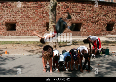 A Street Performer springt über eine Linie von Kindern im Battery Park New York außerhalb Castle Clinton Stockfoto