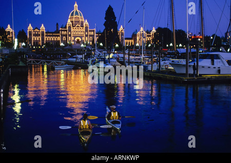 Zwei Kajakfahrer Paddel in Victorias Innenhafen mit dem Parlamentsgebäude beleuchtet in der Nacht, Victoria, Vancouver Island, British Stockfoto