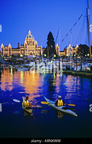 Zwei Kajakfahrer Paddel in Victorias Innenhafen mit dem Parlamentsgebäude beleuchtet in der Nacht, Victoria, Vancouver Island, British Stockfoto