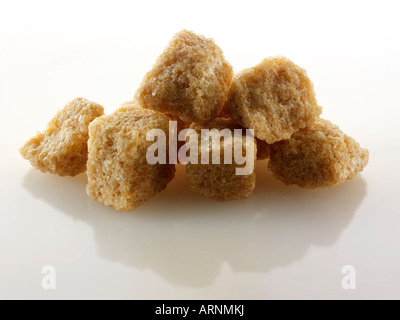 Grob geschnittene demerara Zuckerwürfel noch Leben gegen ein Weiß Hintergrund Stockfoto