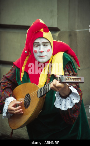 Straßenmusikant verkleidet als Joker und die laute spielen, während des Edinburgh Festival Fringe Stockfoto