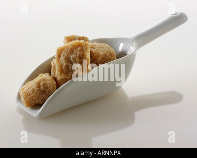 Demerara roh geschnittene Zuckerwürfel noch Leben gegen ein Weiß Hintergrund Stockfoto