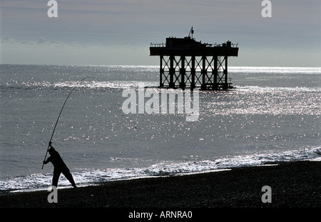 Angler wirft seine Angelschnur aus Strand, Sizewell, Suffolk, England. Stockfoto