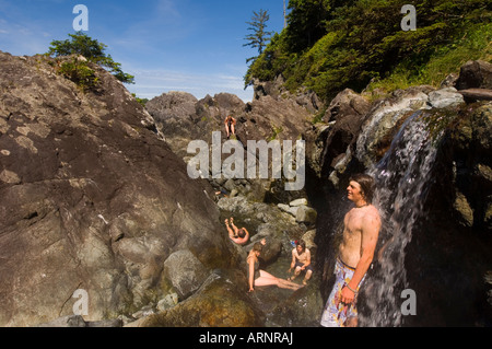 Hot Springs Cove mit jungen Mann unter warmen Wasserfall, Vancouver Island, British Columbia, Kanada. Stockfoto