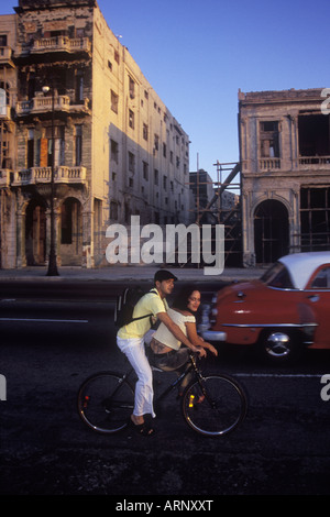 Kuba, Havanna - Altbauten auf dem Malecon, kubanischen paar auf dem Fahrrad. Stockfoto