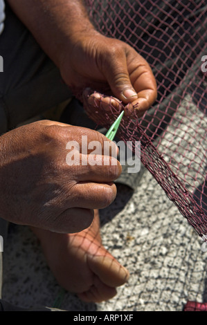 Nahaufnahme von Fischer s Hände und Finger Reparatur Netze am Kai Stockfoto