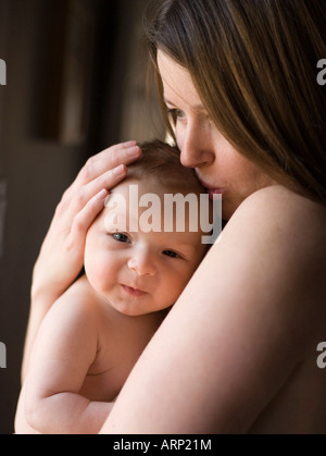Porträt der Mutter halten zwei Monate altes Baby junge Haut an Haut, hand auf Kopf, Fensterlicht, umarmen, halten Stockfoto
