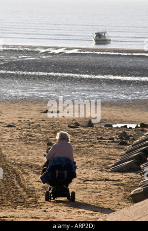 Ältere weibliche motorisierten Rollstuhl Strand Stockfoto