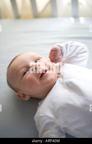 drei Monate altes Baby lächelnd in Krippe Stockfoto