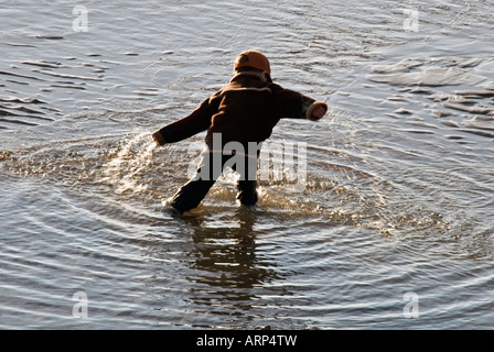 Junge Kind paddeln Meer Winterkleid Stockfoto