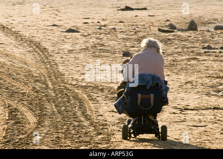 Ältere weibliche motorisierten Rollstuhl Strand Stockfoto