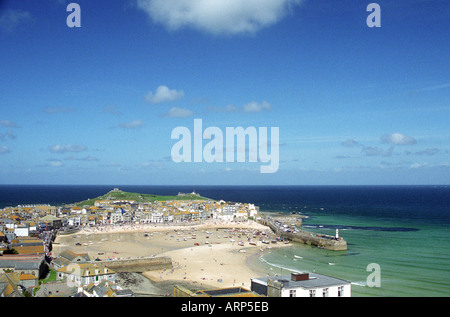 Blick über St. Ives, den Hafen und bei Ebbe auf das Meer mit Booten auf Sand. Fisherman's Chapel of St. Nicholas auf der Landzunge. St Ives, Cornwall, Großbritannien. Stockfoto
