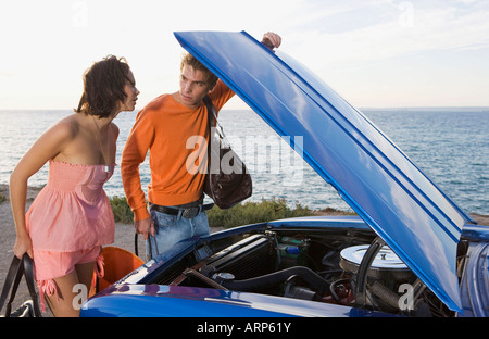 Mann und Frau unter Motorhaube Stockfoto