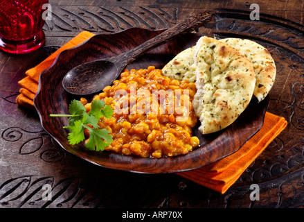 Tadka daal mit Naan-Brot auf einer Holzplatte mit orange Serviette auf eine Herkunft aus Holz. Stockfoto