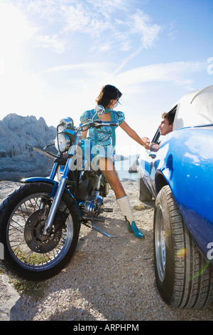 Mann im Auto Frau auf Motorrad Stockfoto