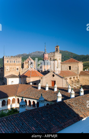 Guadalupe, Extremadura, Spanien. Türme des Real Monasterio de Santa María de Guadalupe, Dach des Parador im Vordergrund. Stockfoto