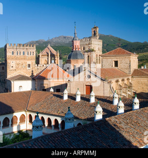 Guadalupe, Extremadura, Spanien. Türme des Real Monasterio de Santa María de Guadalupe, Dach des Parador im Vordergrund. Stockfoto