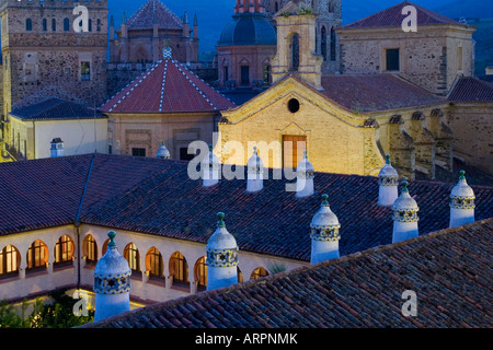 Guadalupe, Extremadura, Spanien. Die Real Monasterio de Santa María de Guadalupe in der Abenddämmerung, Dach des Parador im Vordergrund. Stockfoto