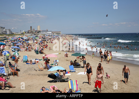 Surfline von Jersey Shore Strand mit Masse von Menschen vermischt mit bunten Sonnenschirmen und Banner Flyer. Stockfoto