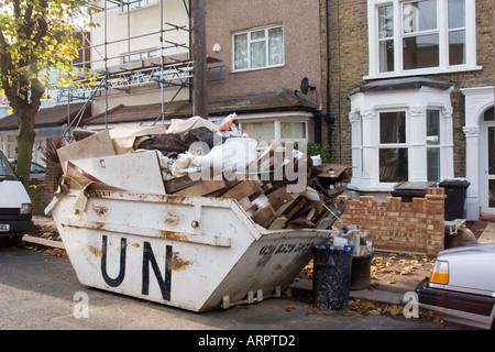 Überladene Skip in der Straße.  DIY voller Müll außerhalb privaten Wohn-Gehäuse Chingford North East London UK Stockfoto