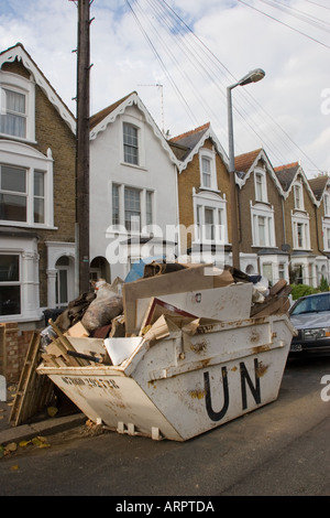 Überladene Skip in Straße, voll von DIY Müll außerhalb privaten Wohn-Gehäuse Chingford North East London UK Stockfoto