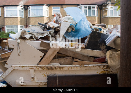 Überladene Skip in Straße, voll von DIY Müll außerhalb privaten Wohn-Gehäuse Chingford North East London UK Stockfoto