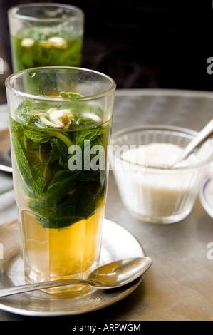 Traditionelle marokkanische Pfefferminztee in ein hohes Glas mit Zuckerdose auf Metall Café-Tisch. Stockfoto