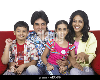 Südasiatische indische Familie mit Vater Mutter Sohn und Tochter sitzen auf einem sofa Stockfoto