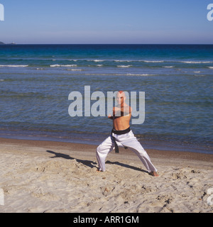 Professional-Tai-Chi und Kong Fu Lehrer Unternehmen Training am Strand in Mallorca, Balearen, Spanien. Stockfoto