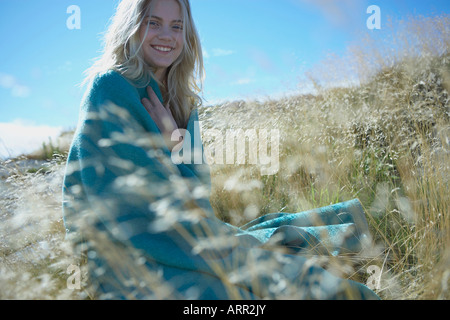 Junge Frau sitzt lange Gras Stockfoto