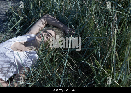 Junge Frau in langen Rasen liegen Stockfoto