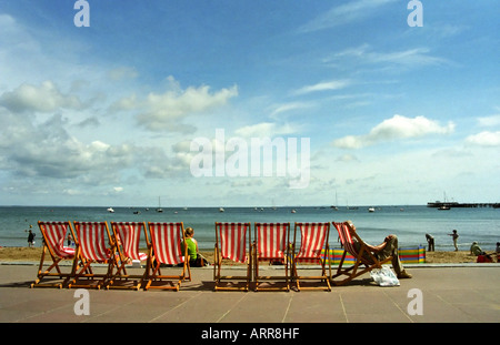 Eine Reihe von Liegestühlen auf Swanage direkt am Meer an einem sonnigen Sommertag Stockfoto