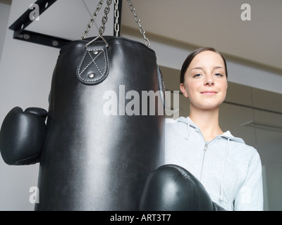 Junge Boxerin mit Handschuhen am Boxsack Stockfoto