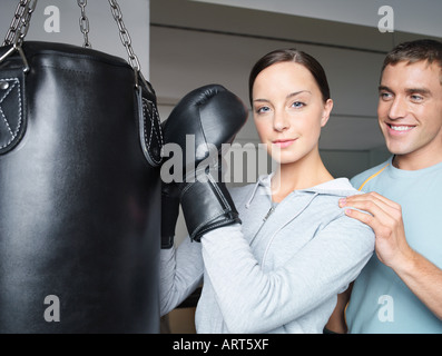 Lehrer und junge Boxerin am Boxsack Stockfoto