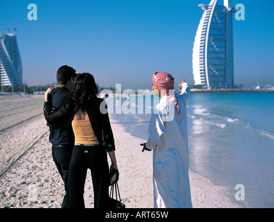 Arabische Mann zeigt Touristen aus dem Westen das Burj Al Arab Hotel in Dubai, Vereinigte Arabische Emirate Stockfoto