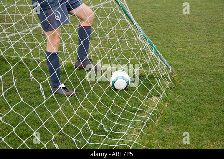 Fußballer im Tor mit Fußball Stockfoto