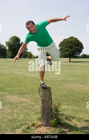 Mann, balancieren auf Baumstumpf Stockfoto